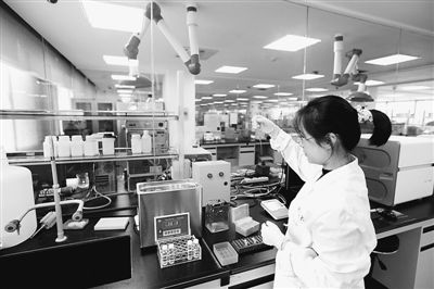 中国科大生命科学实验中心的技术人员在科学仪器前做测试分析。